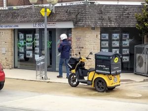 Photo d'un facteur et du Staby, scooter électrique plus ou moins ergonomique